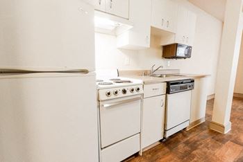 A kitchen with white appliances and white cabinets